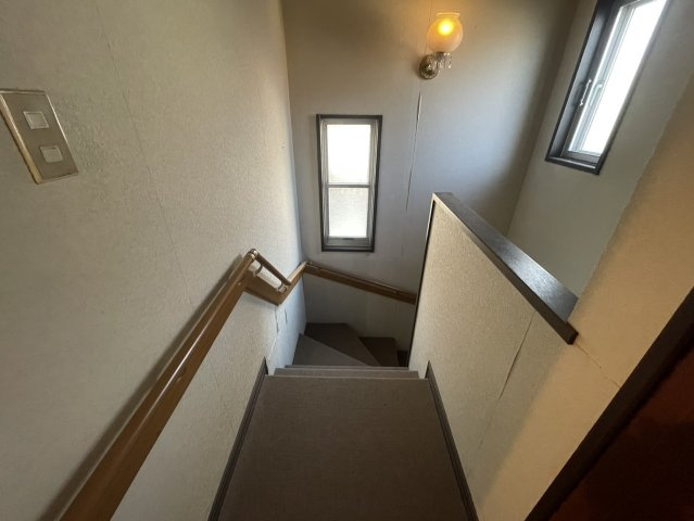 階段にはしっかりとした手すりが設置されており、安全面にも配慮されています。2つの窓から自然光が差し込み、日中でも明るく安心して昇降できる設計です。ご高齢の方やお子様のいるご家庭にも優しい造りです。
