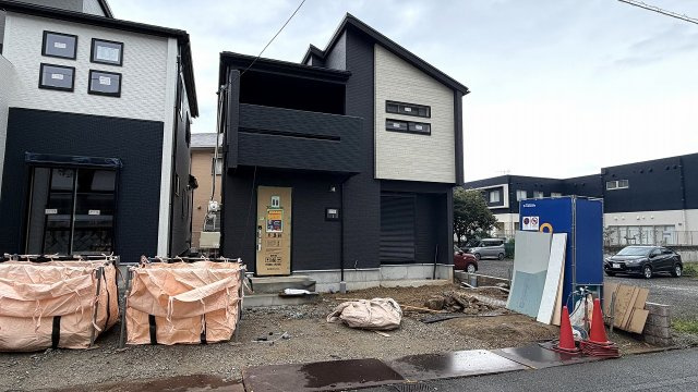 黒い外壁に白いアクセントが映える建物正面