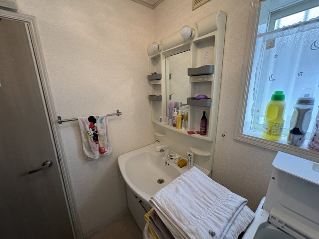 洗面台は収納付きで、洗面用品や日用品をすっきり整理可能。鏡まわりにも収納スペースがあり、朝の身支度がスムーズに行えます。窓から自然光が入り、明るく清潔感のある洗面空間です。