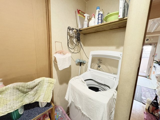 室内に設けられた洗濯機置き場は、天候に左右されず家事ができる便利なスペース。収納棚もあり、洗剤や掃除用品などもまとめて管理できます。水回りとの動線も良く、日々の家事効率を高めてくれる設計です。