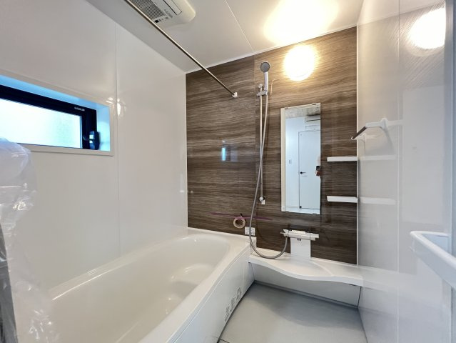 シックな木目のアクセントパネルが落ち着いた浴室