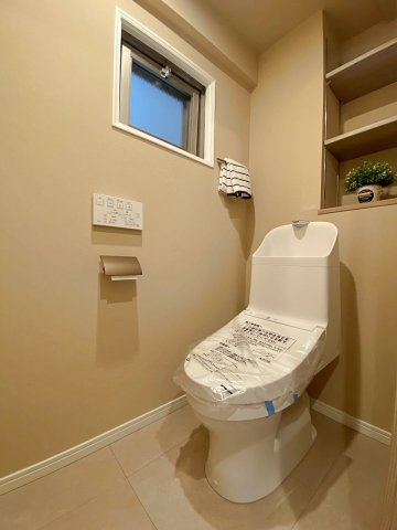 快適なウォシュレット機能を備えた新規交換済みの清潔なトイレ空間。毎日使う場所だからこそ、衛生面と居心地の良さにこだわりました。上部に収納スペースもあり、ペーパー類もすっきり収まります。