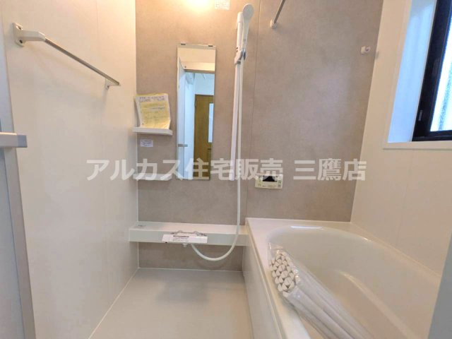 鏡や収納棚、カウンターを備え、入浴用品を整理しやすい浴室です。