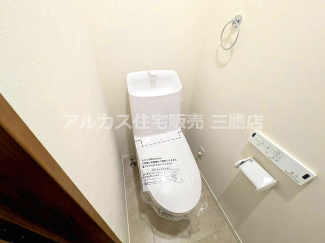　手洗い付き便器と壁付けリモコンを備えた、すっきりとしたトイレです。