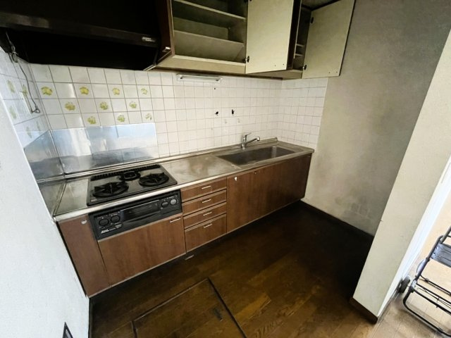 3口コンロ付きの壁付けキッチン。上下に収納があります。