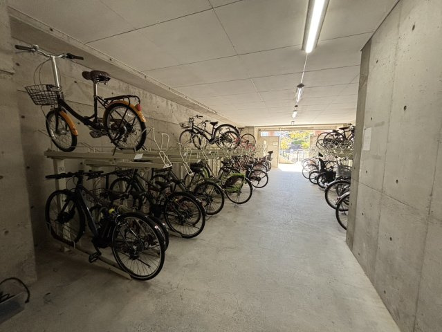 屋内型の駐輪スペースを完備し、雨の日でも安心して自転車を保管できます。二段式ラックで整理整頓されており、出し入れもスムーズです。通勤・通学にも便利な設備で、快適な日常をサポートします。