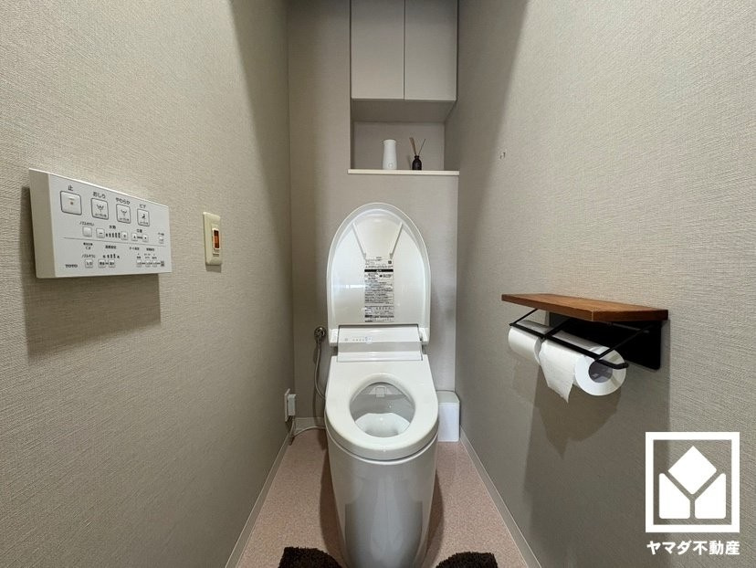 明るく清潔感溢れるトイレです。温水洗浄便座付きで、季節を問わずいつでも温かい便座をお使いいただけます。トイレットペーパーのストックや消耗品置き場などとしてお使いいただける吊戸棚がございます。