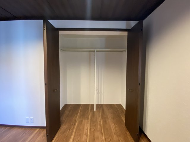 ワイドタイプのクローゼットは、左右にしっかりとハンガーパイプを備えた使いやすい設計です。奥行きも十分に確保されているため、コートやスーツはもちろん、季節物の衣類や収納ケースもゆとりをもって収まります。