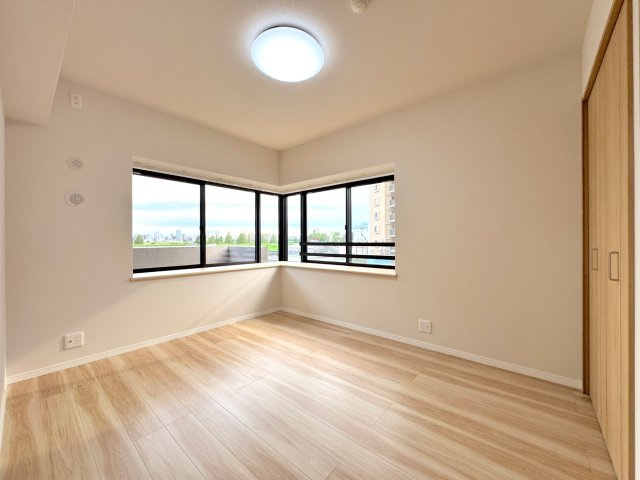 【洋室（5.4帖・南西側）】　2面採光の角部屋で、明るい陽光と心地よい風を感じられるお部屋です。便利な収納付きで空間を広く使え、書斎や趣味の部屋としても心地よくお過ごしいただけます。