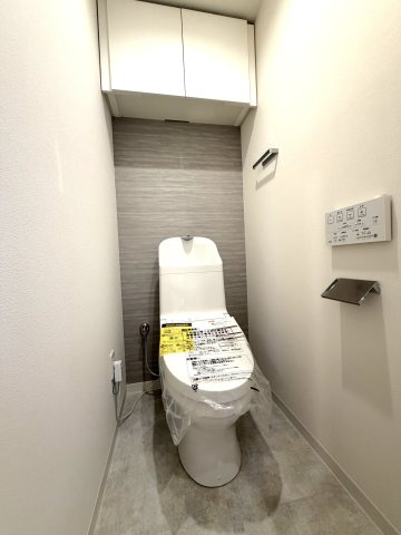 清潔感あふれる白を基調に、背面のグレーのアクセントクロスが空間を引き締めるオシャレなトイレです。