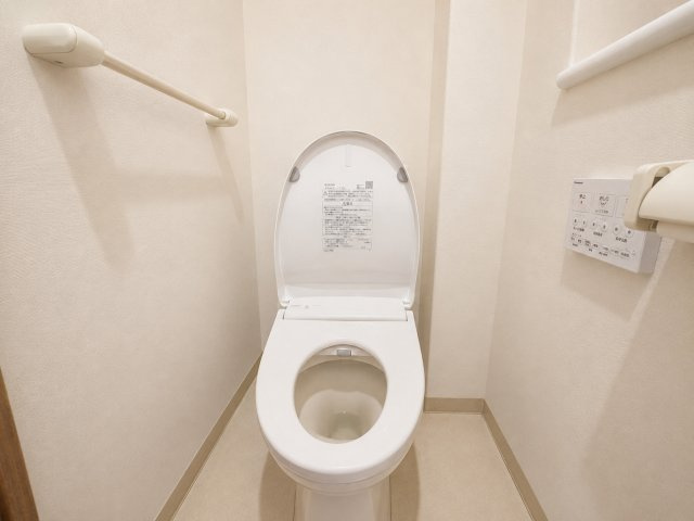 清潔感のあるホワイトを基調としたトイレ空間です。温水洗浄便座を備え壁面には操作パネルが設置されています。コンパクトながらもすっきりとしたレイアウトで毎日快適に使用できる空間となっています。　