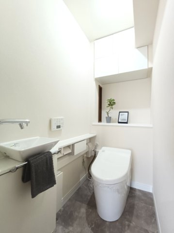 【トイレ】　タンクレスのトイレには便利な手洗い水栓付き！機能性とデザイン性を兼ね備えた空間です。