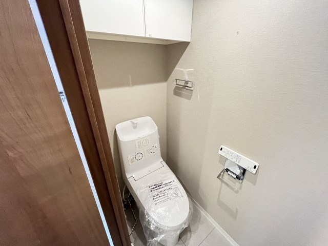 上部収納と温水洗浄便座機能が完備されたトイレ