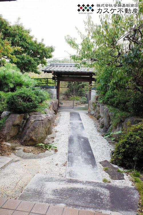 立派な門から玄関へと続くアプローチ。両脇には松の木や庭石が並んでいます。