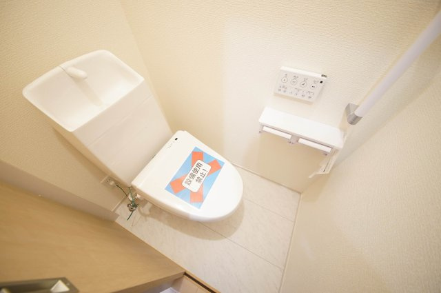 手すり付きで利用する際安心なトイレ、温水洗浄機能付きです