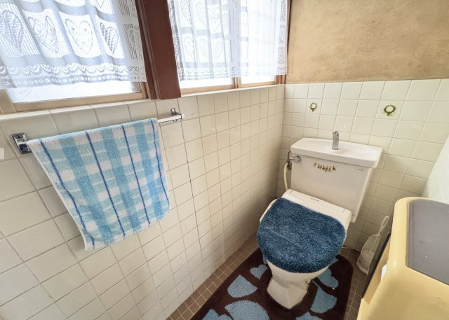 窓付きで自然換気ができる、明るいトイレスペースです。タイル張りのレトロな雰囲気が特徴で、清潔感のある空間。手すりも設置されており、使い勝手にも配慮。落ち着いた住宅街の中で、ゆったりとした暮らしを実現。