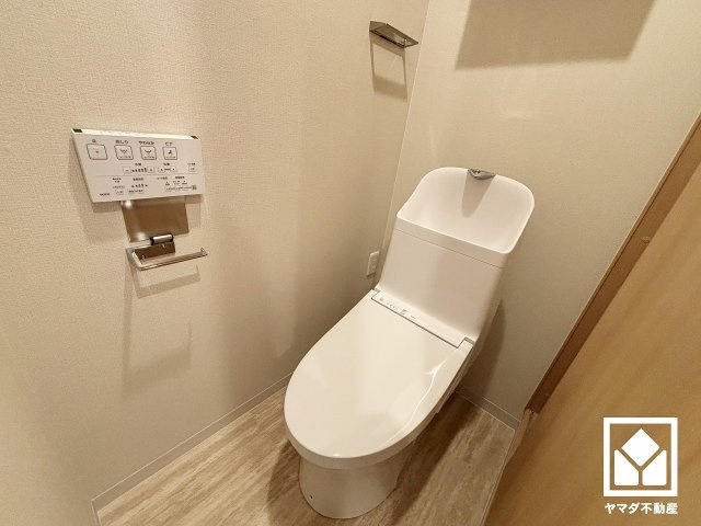明るく清潔感溢れるトイレです。トイレットペーパーのストックや消耗品置き場などとしてお使いいただける吊戸棚がございます。
