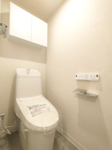 【トイレ】　洗浄機能付きトイレ。上部には収納付で、トイレットペーパー等、買い置きもしやすそうです。