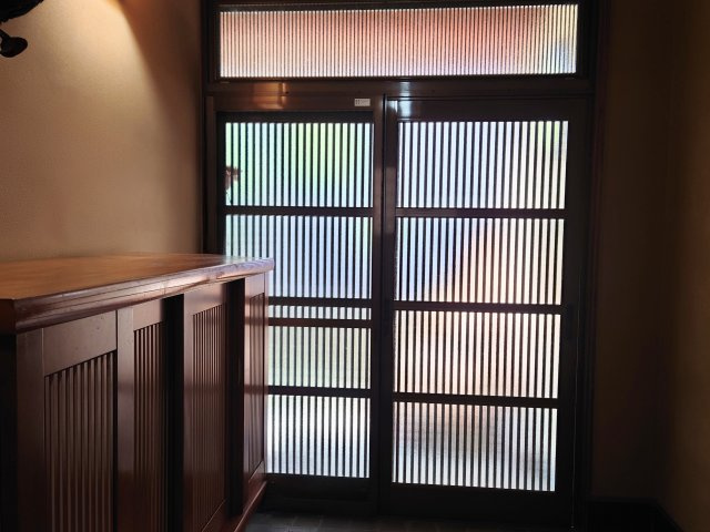 格子戸から柔らかな光が差し込む趣ある玄関。