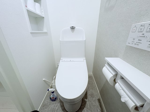 温水洗浄便座付きの清潔感あふれるトイレです。シンプルで落ち着いた内装は飽きが来にくく、お掃除もしやすい仕様です。上部収納やペーパーホルダー付きカウンターを備えており、日用品をすっきり整理できます。
