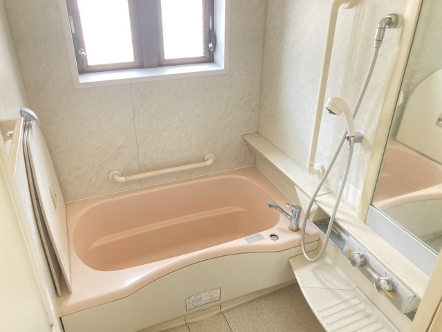 窓を備えた浴室は自然光を取り込みながら換気もしやすいのが魅力。浴槽には手すりが設けられており、入浴時の立ち座りをサポートします。シャワーや鏡、収納スペースも備え毎日のバスタイムを快適に過ごせる空間です