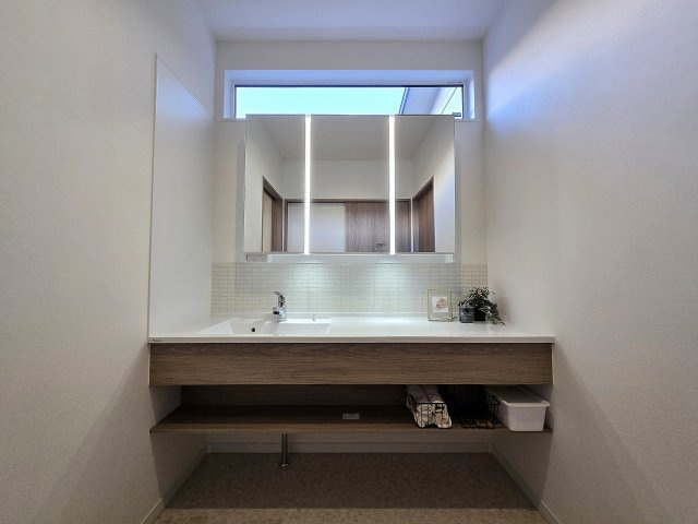 広いカウンターと三面鏡を備えた、使いやすい洗面台。