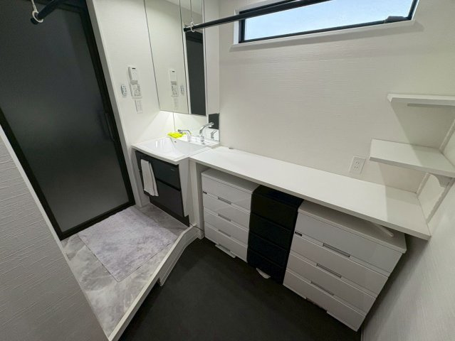 白を基調とした清潔感あふれる洗面スペース。三面鏡付きの洗面台は収納力も高く身支度をスムーズに行えます。隣にはカウンターを設けておりタオルや日用品の整理にも便利。生活を快適にサポートする機能的な空間です