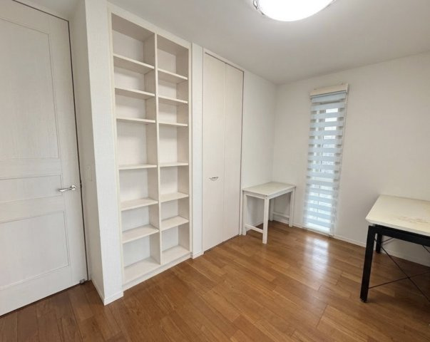 可動棚付きの収納スペースが設けられた洋室で、本や小物をすっきり整理可能。書斎や子供部屋としても使いやすく、用途に応じたレイアウトが可能です。窓もあり、明るく快適に過ごせる空間です。