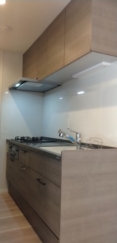 上部に吊り戸棚が設置された、浄水器付きのシステムキッチンです