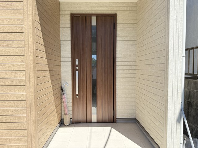 木目調のドアが印象的な玄関は、落ち着いた雰囲気と温かみを演出しています。屋根付きのポーチで雨の日も安心して出入りが可能。ゆとりあるスペースがあり、来客時にも快適に迎え入れることができます。　　