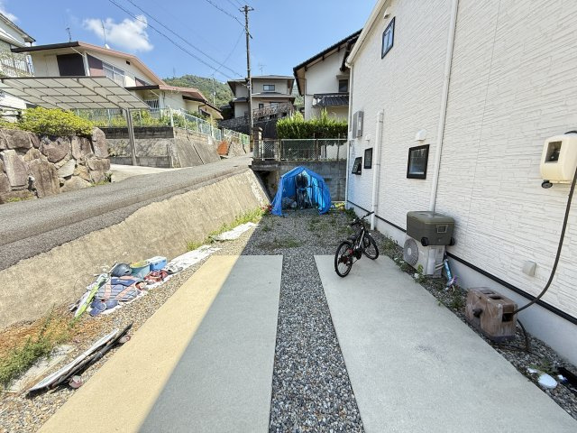 建物横のスペースは自転車やバイクの駐輪物置の設置など多目的に利用できる便利なエリアです。砂利敷きで雨の日も泥はねが少なく手入れもしやすい環境。道路からのアクセスも良好で趣味のスペースとして活用できます