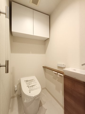 【トイレ】　洗浄機能付きのタンクレストイレ。上部には収納付で、トイレットペーパー等、買い置きもしやすそうです。