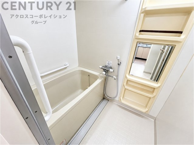 ゆったりとくつろげる浴槽を備えた、清潔感のあるバスルーム。手すり付きで入浴時の動作をサポートします。鏡や収納スペースも設けられ、毎日のバスタイムを快適に過ごせます。