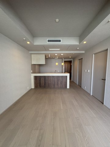優美な間接照明の光が空間を包み込む、洗練されたリビングダイニング。木目調のフローリングと落ち着いたトーンの内装が調和し、モダンな住空間を演出します。家具の配置がしやすい、奥行きのあるレイアウトです。