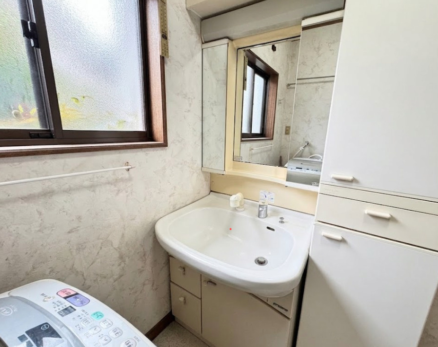 窓付きで自然光が入る明るい洗面スペース。広めの洗面ボウルと収納付きの洗面台で、朝の身支度もスムーズに行えます。隣には洗濯機置き場もあり、家事動線も良好。日常の使い勝手に配慮された空間。