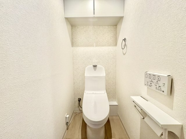 トイレ上部にはトイレットペーパーや掃除用品をすっきり目隠し収納できる扉付きの吊戸棚を設置。余計なものを床に置かずに済むため、空間を広く使えてお掃除も簡単、常に清潔な状態をキープできます