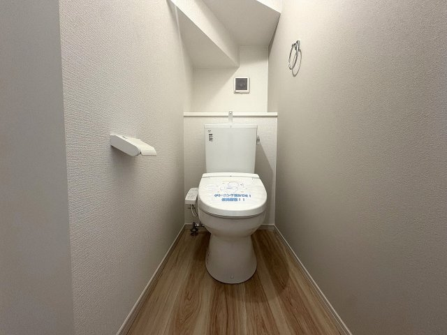 手洗い器と収納棚を備えた清潔感のあるトイレです。