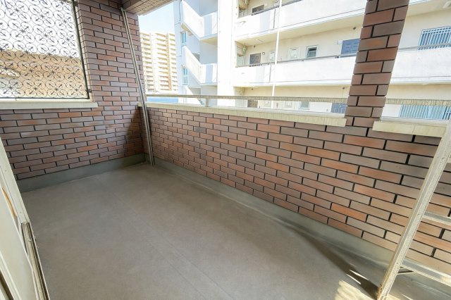 レンガ調の壁が印象的なバルコニーはしっかり奥行きがあり洗濯物干しにもゆとりのある広さ。外からの視線を程よく遮りつつ光と風を取り込める設計です。天候の良い日は椅子を置いてくつろぐなど多目的に活用できます