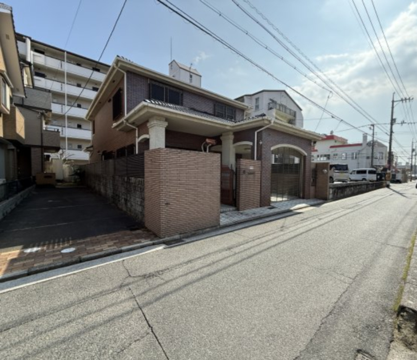 前面道路は見通しが良く、車の出入りもしやすい立地。周辺はマンションや戸建てが立ち並ぶ住宅エリアで、生活利便施設も身近に揃います。敷地は道路にゆとりをもって接しており、開放感のある佇まいです。