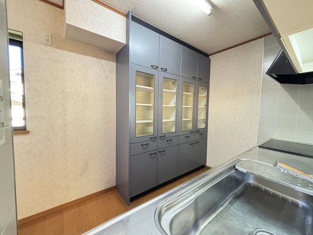 キッチン背面には大容量の収納棚を完備。ガラス扉付きで中が見やすく食器や調理器具、調味料のストックまできれいに整理できます。高さのある造りで収納力豊富、キッチン周りをすっきり保てるのが魅力。