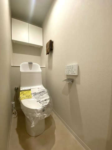 清潔感のある新規交換済みの温水洗浄便座付きトイレです。節水機能やお手入れのしやすさに優れており、毎日快適にご使用いただけます。上部吊戸棚などの収納スペースも充実しており空間をすっきり保てます。