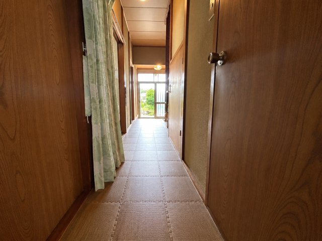 室内をつなぐ廊下は木目を基調とした落ち着きのある空間。奥には開口部があり、自然光が差し込むことで明るさも感じられます。各居室や水回りへ移動しやすく昔ながらの戸建住宅らしい温かみのある内装も印象的です。
