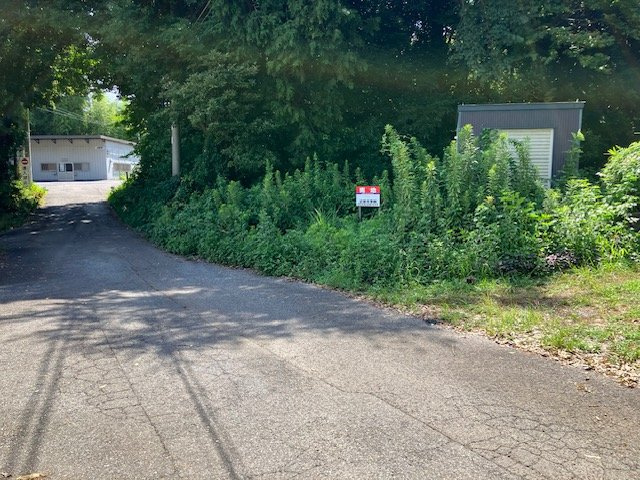 土地の接している北西側道路から北側へ向かうと、道路の入口があり、東西の道路と接しています。その道路の東側から西へ向かって撮影しました。