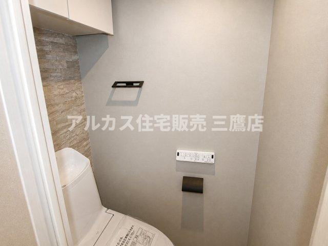 レンガ風のアクセントクロスやブラックのペーパーホルダーがおしゃれな、落ち着きのあるトイレスペース。