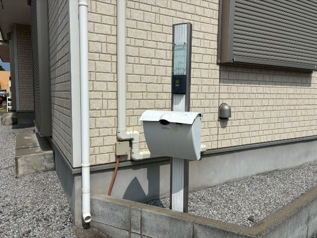 【防犯設備】現地完成写真。建物入口には郵便ポストと一体のインターホンがございます。