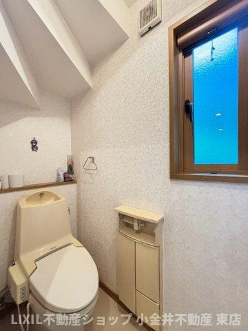 【トイレ】現地写真：採光・換気窓のあるトイレはトイレットペーパーホルダーに十分な収納がついています。また、2階にもトイレがございます。
