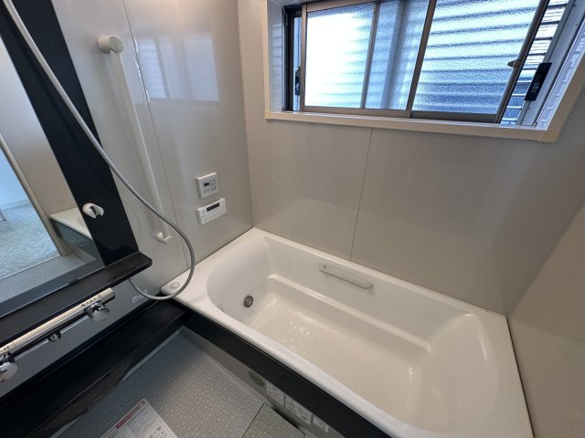 【浴室】　窓付きの浴室です。手すりが設置されており、安全な立ち上がりをサポートします。湯船に浸かりながら給湯器リモコンの操作を行えます。