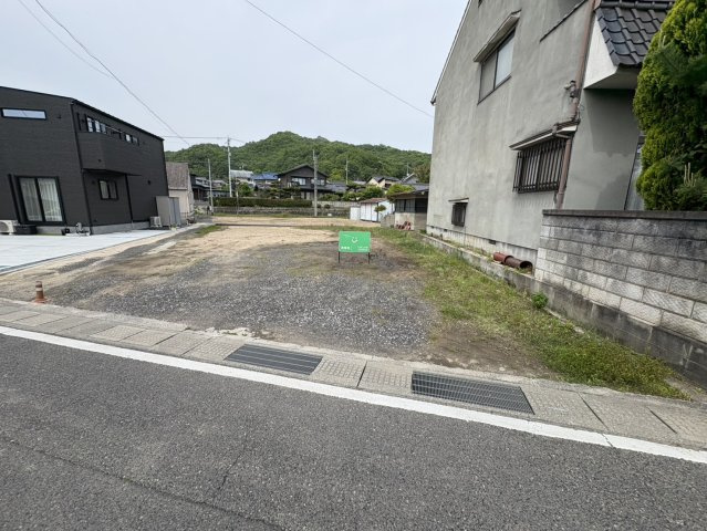 前面道路からの全景が確認できる現地写真です。接道部分が広く、車の出入りもしやすい形状となっており、駐車スペースの確保もしやすい点が魅力。建物配置のイメージがしやすく、マイホーム計画も具体的に検討可能。
