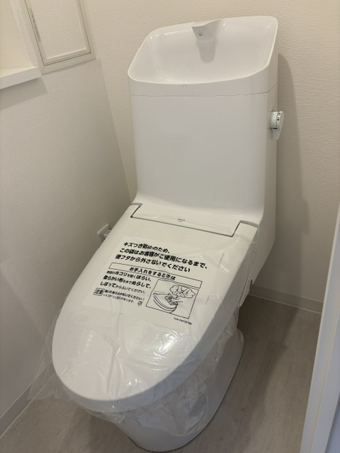 2025年12月に温水洗浄機能付トイレへ新規交換済。手洗い鉢が深く水はねしにくい一体型デザインを採用しています。クロスや床材も張り替えられており、清潔感にあふれた快適なプライベート空間です。