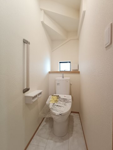 【1階トイレ】　換気と明るさに配慮した、清潔感溢れるトイレ。落ち着いた空間で安らぎのひと時をお過ごしいただけます。